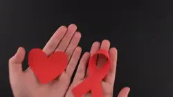 دانلود فوتیج روبان قرمز حمایت از بیماران HIV در دستان یک زن