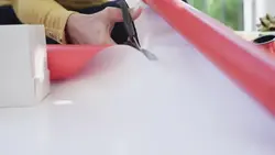 دانلود فوتیج نمای بسته و اسلوموشن از دستان زن در حال قیچی کردن کاغذ کادو