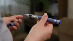 دانلود فوتیج نمای بسته از دستان زن دیابتی در حال آماده کردن سرنگ قلمی انسولین