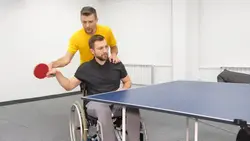 دانلود فوتیج دکتر توانبخشی به فرد روی ویلچر از طریق پینگ پونگ کمک می کند