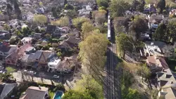 دانلود فوتیج نمای هوایی از عبور قطار از میان شهر کوچک