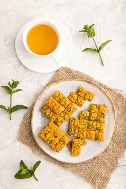 دانلود عکس ظرف سنتی سوهان در کنار یک فنجان چای سبز
