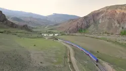 دانلود فوتیج تصویر هوایی حرکت قطار در کوهستان سبز