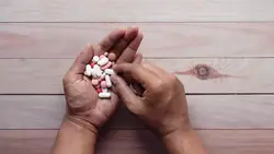 دانلود فوتیج نمای بالا از دست یک مرد در حالی که پر از قرص است