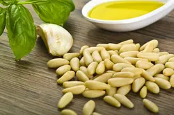 دانلود تصویر شاتراستوک سیر و ریحان و روغن زیتون و دانه های سفید روی میز چوبی کد۱۱۶۵۲۵۶۳۱۶