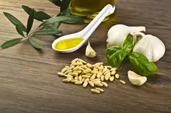 دانلود تصویر شاتراستوک سیر و ریحان و دانه های سفید و روغن زیتون روی میز چوبی کد۲۰۶۶۳۲۵۳۸۵