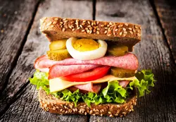 دانلود تصویر شاتراستوک ساندویچ کالباس روی میز چوبی کد۰۳۶۶۶۶۰۱۹۲