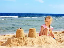 دانلود تصویر شاتراستوک کودک درحال شن بازی در ساحل دریا زمینه آسمان کد۰۰۷۷۱۵۲۴۸۷