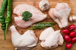 عکس با کیفیت تبلیغاتی فلفل دلمه ای سبز و گوجه و سیر در کنار تکه های مرغ بر روی تخته گوشت