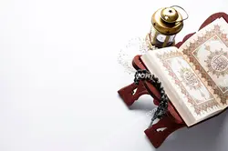 عکس با کیفیت تبلیغاتی قرآن قرار گرفته بر روی رحل و فانوس کوچک در کنارش