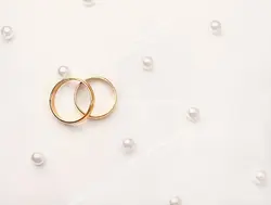 عکس با کیفیت تبلیغاتی دو حلقه طلا روی پارچه مروارید دوزی شده