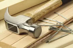 عکس با کیفیت تبلیغاتی چکش و چند میخ که روی سطح چوبی قرار دارند