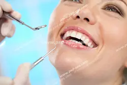 عکس با کیفیت تبلیغاتی پزشک در حال معاینه با آینه و اکسکویتور دندان خانم