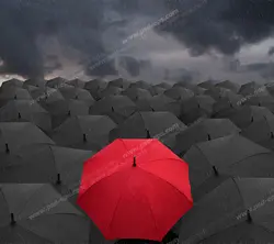 عکس با کیفیت تبلیغاتی یک چتر قرمز در بین چتر های مشکی