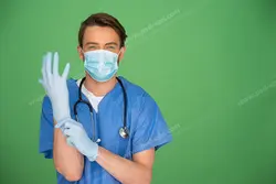 عکس با کیفیت تبلیغاتی پزشک ماسک زده در حال پوشیدن دستکش