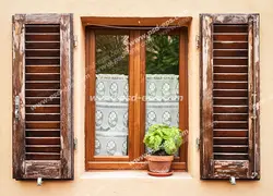 عکس با کیفیت تبلیغاتی پنجره چوبی زیبا با حفاظ چوبی قهوه ای سوخته و یک گلدان سفالی زیبا جلوی آن