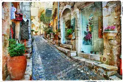 عکس با کیفیت تبلیغاتی کوچه سنگفرش شده با بافت قدیمی خانه هایی تزئین شده با گلدان های بزرگ و کوچک سفالی