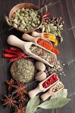 عکس با کیفیت تصویری زیبا از آشپزخانه و ادویه های رنگارنگ درون قاشق های چوبی و کاسه های مسی