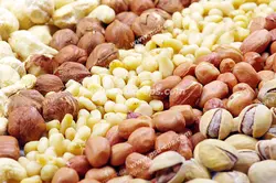 عکس با کیفیت انواع آجیل های مختلف شامل پسته ، بادام هندی ، بادام زمینی و فندق چیده شده در کنار هم