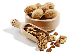 عکس با کیفیت پیاله چوبی بامبو پر از گردو و مغز گردو درون پیمانه بر روی زمینه سفید