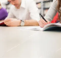 عکس با کیفیت دانشجویان نشسته پشت میز کتابخانه در حال مطالعه کتاب