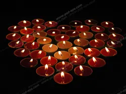 عکس با کیفیت شمع های فانتزی وارمر قرمز و زرد رنگ چیده شده به شکل قلب