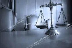 عکس با کیفیت سیاه و سفید از ترازوی عدالت بر روی میز قاضی