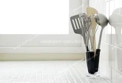 عکس با کیفیت سرویس کفگیر ملاقه استیل با دسته های مشکی درون جاقاشقی بر روی کابینت