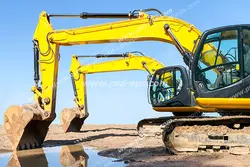 عکس با کیفیت دو عدد بیل مکانیکی با چرخ زنجیر آهنی در حال حفر کانال در زمین های سخت