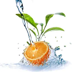 عکس با کیفیت برخورد آب با تکه ای پرتقال در کنار برگ های پرتقال