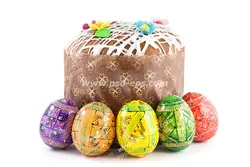 عکس با کیفیت کیک خانگی به همراه تخم مرغ های رنگی چیده شده دور آن