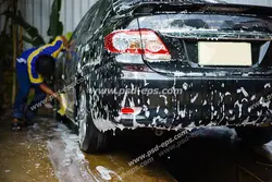 عکس با کیفیت کارواش یا شستشوی خودروی مشکی رنگ با کف و مواد شوینده