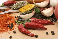 عکس با کیفیت ادویه ها به همراه سیر و پیاز و فلفل قرمز خشک شده بر روی میز چوبی