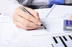 عکس با کیفیت کارمند حسابدار در حال کار بر روی میز پر از برگه ها با ماشین حساب