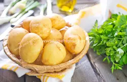 عکس با کیفیت ظرفی حاوی سیب زمینی بر روی میز چوبی به همراه سبزی و غیره