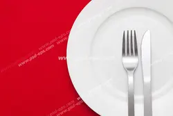عکس با کیفیت پیش دستی پذیرایی یا بشقاب چینی با چاقو و چنگال بر روی زمینه قرمز رنگ