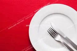 عکس با کیفیت پیش دستی یا بشقاب چینی با چاقو و چنگال بر روی زمینه قرمز رنگ