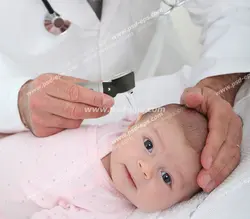 عکس با کیفیت متخصص اطفال در حال معاینه گوش نوزاد توسط اتوسکوپ