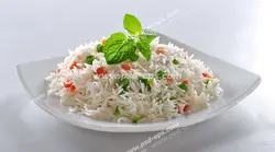 عکس با کیفیت بشقاب حاوی برنج پخته شده به همراه نخود سبز و هویج با تزئین برگ نعنا