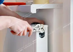 عکس با کیفیت شخصی در حال تعمیر شوفاژ منزل با آچار