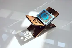 عکس با کیفیت نمایی از تابش آفتاب بر روی قرآن درون رحل با نقش کلمه الله بر روی رحل