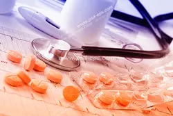 عکس با کیفیت ابزار معاینه تست قند خون و استتوسکوپ و ورق قرص های نارنجی بر روی تست نوار قلب