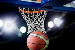 عکس با کیفیت نمای نزدیک از توپ بسکتبال در حال رد شدن از حلقه تور بسکتبال
