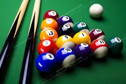 عکس با کیفیت توپ های رنگارنگ بیلیارد و چیده شده در کنار هم و چوب های بیلیارد بر روی میز