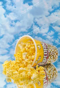 عکس با کیفیت لیوان پاپ کورن پنیری و کچاپ با زمینه آسمان آبی و ابری