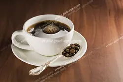 عکس با کیفیت فنجان چینی حاوی نوشیدنی قهوه بر روی نعلبکی در کنار قاشق پر از دانه های قهوه بر روی میز چوبی