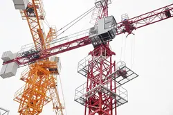 عکس با کیفیت نمای پایین از دو تاور کرین بزرگ زرد و قرمز رنگ ساختمانی