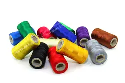 عکس با کیفیت قرقره های نخ رنگارنگ ریخته شده بر روی زمین