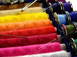 عکس با کیفیت قرقره ها و ماسوره های نخ های رنگارنگ درون جهبه ابزار خیاطی
