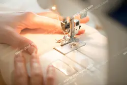 عکس با کیفیت نمای نزدیک کار خیاط با چرخ خیاطی و دوخت راسته دوزی ویژه استفاده در امور تبلیغاتی و تجاری طراحی کاتالوگ ، بروشور و تراکت با موضوع خیاطی ، تولیدی لباس ، آموزش خیاطی یا موسسات فنی و حرفه ای آموزش مقدماتی تا حرفه ای و لباس شب و لباس عروس